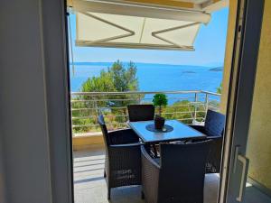 ein Tisch und Stühle auf einem Balkon mit Blick auf das Meer in der Unterkunft Novi Lux in Novi Vinodolski