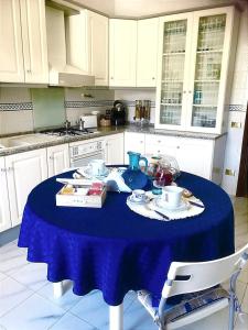 ポルト・エンペードクレにあるB&B Di Mareのキッチン(テーブル、青いテーブルクロス付)