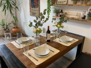 a wooden table with plates and wine glasses on it at Wunderschöne Altbauwohnung in Toplage in Biederitz