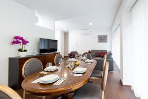 a dining room with a table and chairs and a couch at Villa Mihaela in Bled