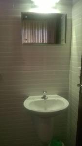 a bathroom with a white sink and a mirror at Anna Homestay in Munnar +33 photos