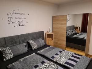1 dormitorio con cama y espejo en la pared en FeWo Brombachsee - Sonnentag Süd, en Röttenbach