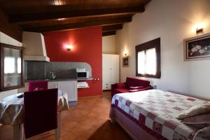 a bedroom with a large bed and a kitchen at Apartamentos Turisticos Sanahuja in Valbona