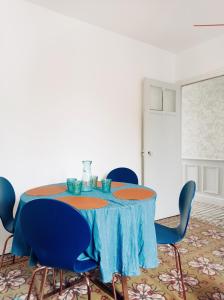 une table avec des chaises bleues et un chiffon de table bleu dans l'établissement Irziana - Au jardin d'Henriville, à Amiens