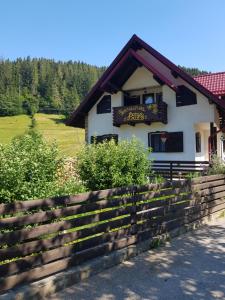 a building with a fence in front of it at Pensiunea Daria Putna in Putna