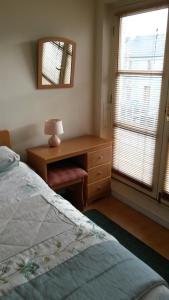 a bedroom with a bed and a desk with a lamp at 30 Quay Village Westport in Westport