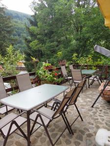 a group of tables and chairs on a patio at Pensiune Casa Barcaru in Azuga