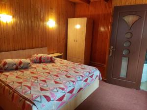 Un pat sau paturi într-o cameră la Pensiune Casa Barcaru