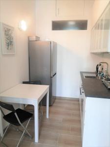 a kitchen with a white table and a refrigerator at Ruhige Art-Garconniere mit Balkon in Vienna