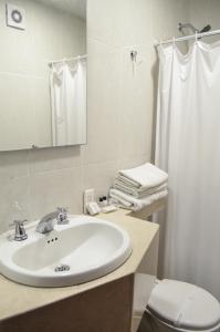 a bathroom with a sink and a toilet and a mirror at Hotel Playa Club in Cartagena de Indias