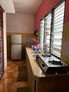 a kitchen with a stove and a refrigerator at Homestay D-Zara in Ipoh