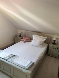 a bed with white sheets and pillows in a room at Pensiunea Daria Putna in Putna