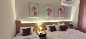 two beds in a hotel room with paintings on the wall at Forest Apartments in Bitola +41 photos