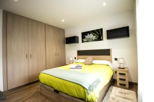 a bedroom with a yellow bed and wooden cabinets at Apt a 5 min del telecabina con vistas al valle in Encamp