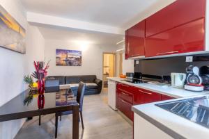 a kitchen with red cabinets and a table in a room at Apartments Ante 2 in Hvar