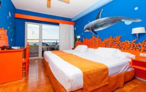 a bedroom with a bed with a dolphin mural on the wall at Diver Aguadulce in Aguadulce