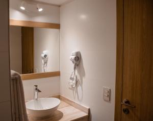 a bathroom with a sink and a mirror at Gran Hotel Dakar in Mendoza