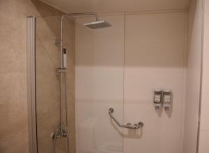 a shower with a glass door in a bathroom at Gran Hotel Dakar in Mendoza