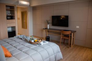 a room with a bed and a table and a television at Gran Hotel Dakar in Mendoza