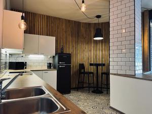 a kitchen with a sink and a black refrigerator at Hotel Vanha Rauma in Rauma
