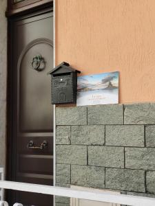 Skrzynka na listy siedząca na murze obok drzwi w obiekcie La Casa In Riva Al Mare w mieście Aci Castello