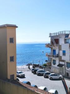 parking z samochodami zaparkowanymi obok oceanu w obiekcie La Casa In Riva Al Mare w mieście Aci Castello +19 zdjęć