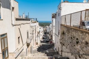 an alley between two buildings with a person walking down it at Petragrigia Vacation Suite in Ostuni