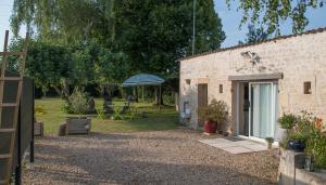 a brick building with a patio and an umbrella at Gîte du timbre in Clion