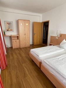 1 Schlafzimmer mit 2 Betten und Holzboden in der Unterkunft zum Schwanen Garni in Buggingen