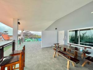 an open living room with benches and a balcony at PrivateRayong in Rayong