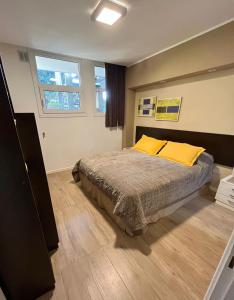 - une chambre avec un lit et deux oreillers jaunes dans l'établissement LA CASA DEL LAGO TANDIL, à Tandil