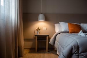 a bedroom with a bed and a table with a lamp at Gran Hotel Dakar in Mendoza