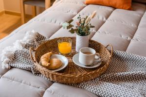 a tray of breakfast foods and coffee on a couch at Gran Hotel Dakar in Mendoza