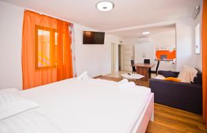 a hotel room with a bed and a couch at Apartments Ante 2 in Hvar