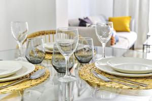 a table with plates and wine glasses on it at Wehaus - Exclusive & nordic style apartment in Murcia in Murcia