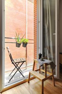 una stanza con una sedia e una finestra con piante di Wehaus - Exclusive & nordic style apartment in Murcia a Murcia