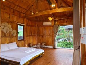a bedroom with a bed in a wooden room at ByVe Garden in Hanoi