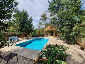 una piscina en un patio con una casa en Eco-Turismo Guayacanes, en Sámara