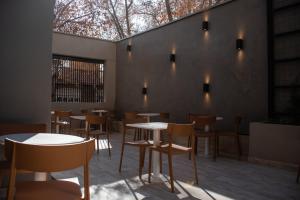 a restaurant with tables and chairs and a wall with lights at Gran Hotel Dakar in Mendoza