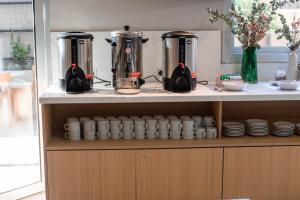 a kitchen with two kettles and cups on a shelf at Gran Hotel Dakar in Mendoza