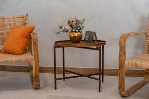 a table with a vase of flowers on it next to a chair at Gran Hotel Dakar in Mendoza