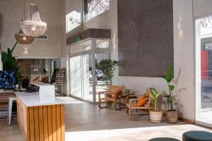 a living room with chairs and a table and some plants at Gran Hotel Dakar in Mendoza