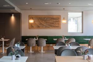 a restaurant with tables and chairs and a picture on the wall at Gran Hotel Dakar in Mendoza
