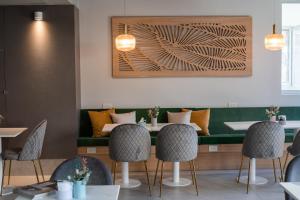 a dining room with a green bench and chairs at Gran Hotel Dakar in Mendoza