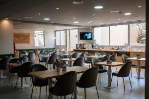 a restaurant with tables and chairs and a bar at Gran Hotel Dakar in Mendoza