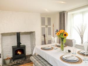 a dining room with a table with a fireplace at Hope Cottage in Buckfastleigh