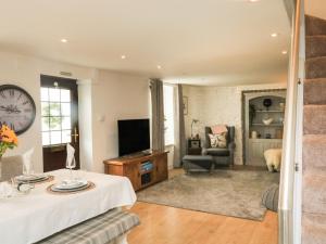 a living room with a clock on the wall at Hope Cottage in Buckfastleigh