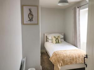 a bedroom with a bed and a picture of a deer on the wall at Hope Cottage in Buckfastleigh