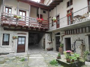 um pátio de um edifício antigo com vasos de plantas em La corte del pane em Valbrona