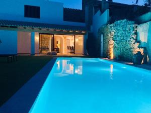 a swimming pool in front of a house at night at Can Roig in Ses Salines